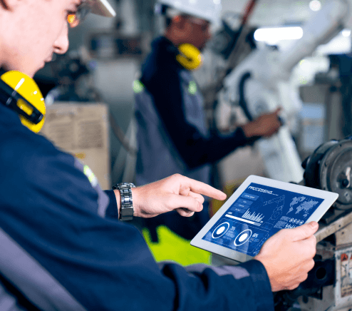 Factory workers operating a robotic arm in a workshop